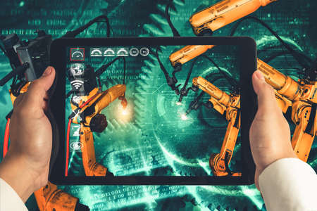 Engineer controls robotic arms by augmented reality industry technology application software. Smart robot machine in future factory working in concept of Industry 4.0 or 4th industrial revolution.の写真素材