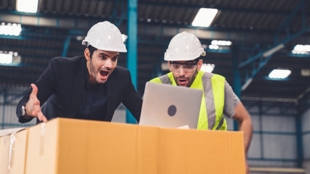 Two factory worker celebrate success together in the factory or warehouse . Industry work achievement concept .の写真素材