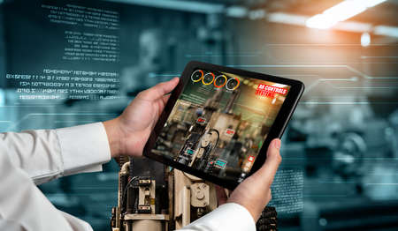 Engineer use augmented reality software in smart factory production line with automated application . Futuristic machinery in working in concept of Industry 4.0 or 4th industrial revolution.の写真素材