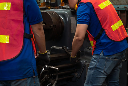 Group of skillful factory workers using machine equipment in workshop . Industry and engineering people technology concept .の写真素材