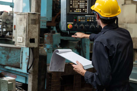 Skillful factory worker working with clipboard to do job procedure checklist . Factory production line occupation quality control concept .の写真素材