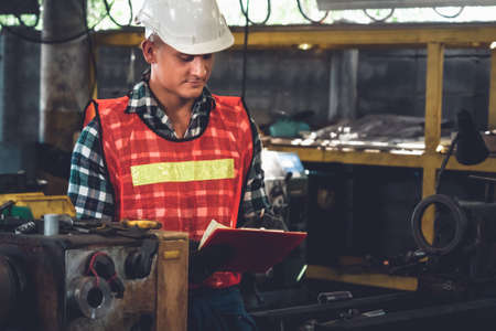 Manufacturing worker working with clipboard to do job procedure checklist . Factory production line occupation quality control concept .の写真素材