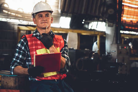 Manufacturing worker working with clipboard to do job procedure checklist . Factory production line occupation quality control concept .の写真素材