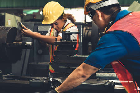 Group of skillful workers using machine equipment in factory workshop . Industry and engineering people technology concept .の写真素材