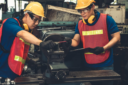 Group of skillful factory workers using machine equipment in workshop . Industry and engineering people technology concept .の写真素材
