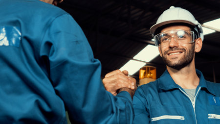 Two skillful factory engineer or worker showing teamwork and partnership . Industrial people and manufacturing labor concept .の写真素材
