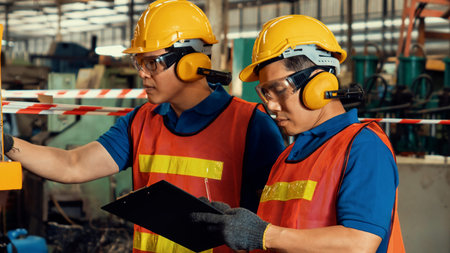 Group of skillful factory workers using machine equipment in workshop . Industry and engineering...