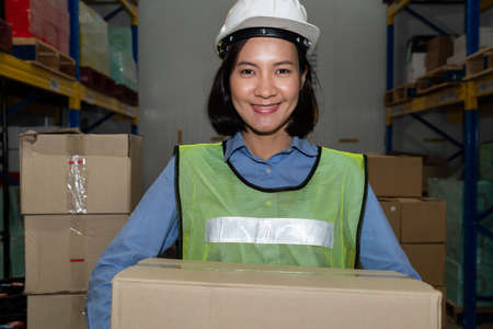 Portrait of young Asian woman warehouse worker smiling in the storehouse . Logistics , supply chain and warehouse business concept .の写真素材