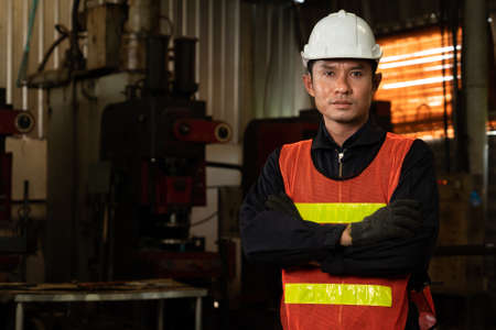 Young factory job worker or engineer close up portrait in manufacturing factory . Industry and engineering concept .の写真素材