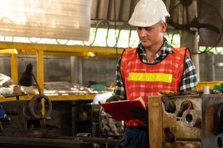 Manufacturing worker working with clipboard to do job procedure checklist . Factory production line occupation quality control concept .の写真素材