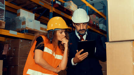 Warehouse senior manager discuss with worker in the storehouse . Logistics , supply chain and warehouse business concept .の写真素材