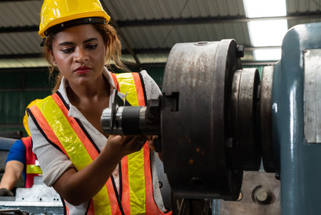Skillful factory woman worker do machine job in manufacturing workshop . Industrial people and manufacturing labor concept .の写真素材
