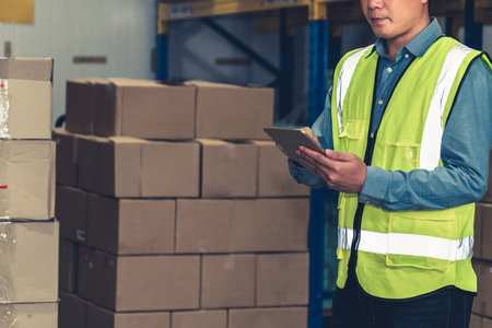 Asian warehouse worker checking packages in storehouse . Logistics , supply chain and warehouse...