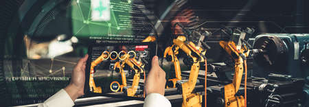 Engineer controls robotic arms by augmented reality industry technology application software. Smart robot machine in future factory working in concept of Industry 4.0 or 4th industrial revolution.の写真素材