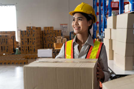 Female warehouse worker working at the storehouse . Logistics , supply chain and warehouse business concept .の写真素材
