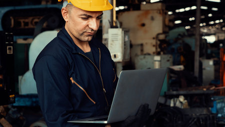 Skillful factory worker working with laptop computer to do procedure checklist . Factory production...