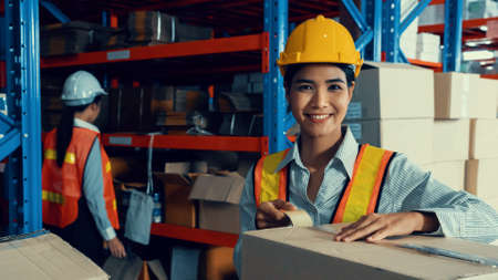 Portrait of young Asian woman warehouse worker smiling in the storehouse . Logistics , supply chain and warehouse business concept .の写真素材
