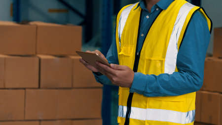 Asian warehouse worker checking packages in storehouse . Logistics , supply chain and warehouse business concept .の写真素材