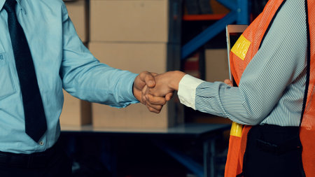 Warehouse worker handshake with manager in storehouse . Logistics , supply chain and warehouse business concept .の写真素材
