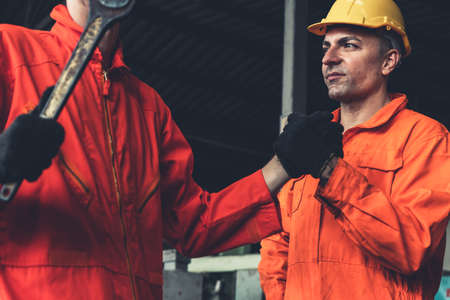 Two skillful factory engineer or worker showing teamwork and partnership . Industrial people and manufacturing labor concept .の写真素材