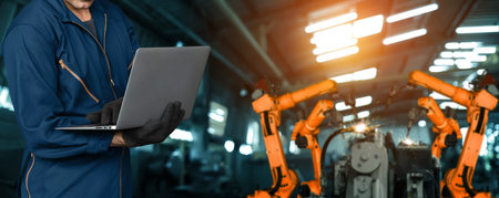 Engineer use advanced robotic software to control industry robot arm in factory . Automation manufacturing process controlled by specialist using IOT software connected to internet network .の写真素材