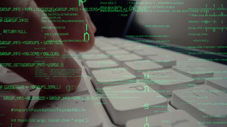 Creative visual of computer programming coding and software development shown by man working on computer keyboard with overlay of computer graphic displaying abstract program codes and computer scriptの写真素材