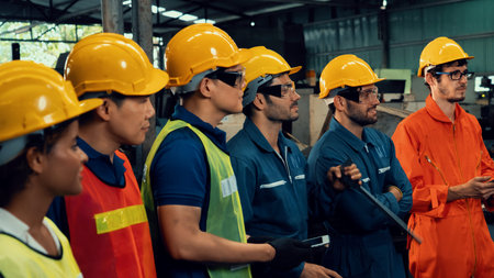 Skillful worker attending brief meeting in the factory . Industrial people and manufacturing labor...