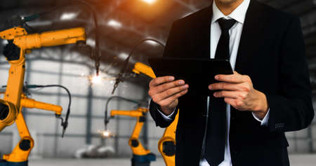 Engineer use advanced robotic software to control industry robot arm in factory . Automation manufacturing process controlled by specialist using IOT software connected to internet network .の写真素材