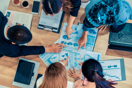 Top view of businessman executive in group meeting with other businessmen and businesswomen in modern office with laptop computer, coffee and document on table. People corporate business team concept.の写真素材