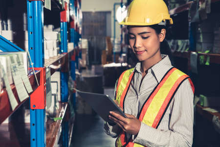 Female warehouse worker working at the storehouse . Logistics , supply chain and warehouse business concept .の写真素材