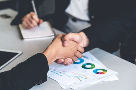 Business people agreement concept. Businessman and Asian businesswoman do handshake in the office.の写真素材