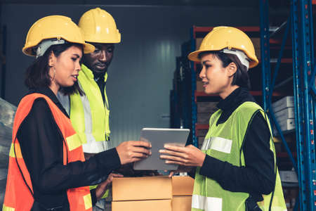 Warehouse worker working together in the storehouse . Logistics , supply chain and warehouse business concept .の写真素材