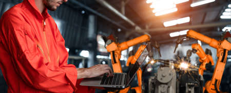 Engineer use advanced robotic software to control industry robot arm in factory . Automation manufacturing process controlled by specialist using IOT software connected to internet network .の写真素材