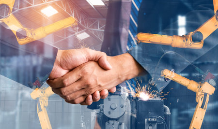 Mechanized industry robot arm and business handshake double exposure