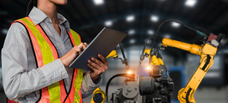 Engineer use advanced robotic software to control industry robot arm in factory . Automation manufacturing process controlled by specialist using IOT software connected to internet network .の写真素材