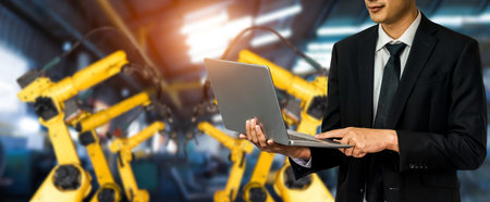 Engineer use advanced robotic software to control industry robot arm in factory . Automation...