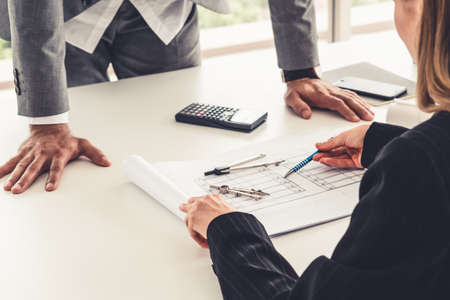 Architect and engineer working with construction drawing project on table in office. Architecture and engineering business concept.の写真素材