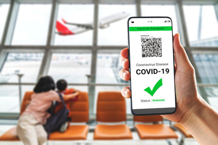 Traveler holds vaccine passport certificate to show COVID 19 vaccination status . The digital health...