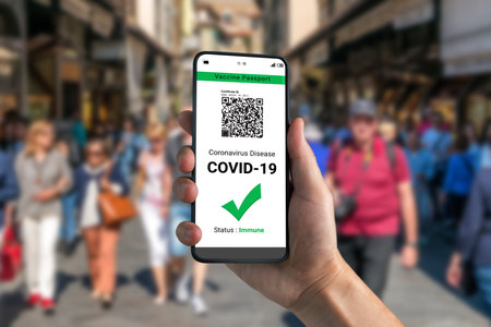 Traveler holds vaccine passport certificate to show COVID 19 vaccination status . The digital health...