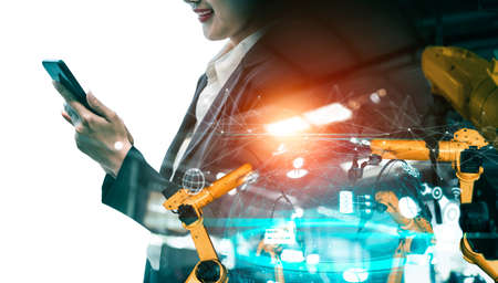 Mechanized industry robot arm and factory worker double exposure . Concept of robotics technology for industrial revolution and automated manufacturing process .の写真素材