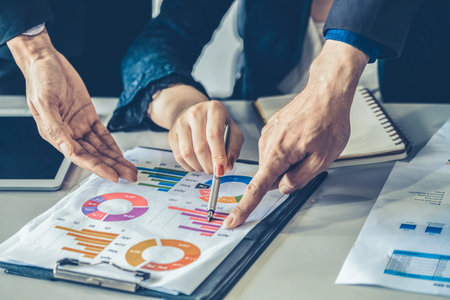 Businessman and businesswoman in meeting working with many financial statement document on desk....