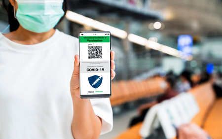 Traveler holds vaccine passport certificate to show COVID 19 vaccination status . The digital health...