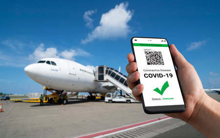 Traveler holds vaccine passport certificate to show COVID 19 vaccination status . The digital health...