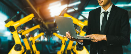 Engineer use advanced robotic software to control industry robot arm in factory . Automation...