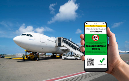 Traveler holds vaccine passport certificate to show COVID 19 vaccination status . The digital health...