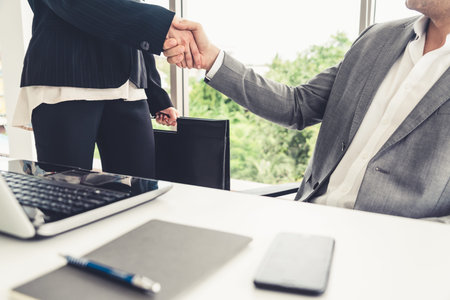 Businessman executive handshake with businesswoman worker in modern workplace office. People...
