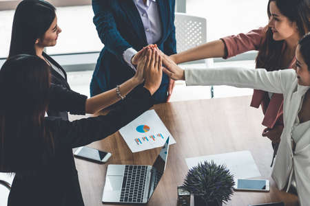 Businesswomen joining hands in group meeting at modern office room showing teamwork, support and unity in work and business. Female power and femininity concept.の写真素材
