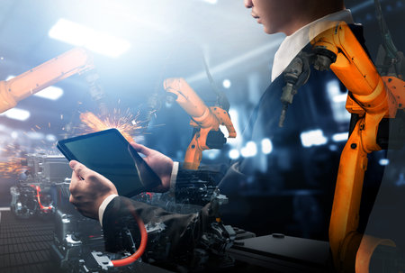 Mechanized industry robot arm and factory worker double exposure . Concept of robotics technology...