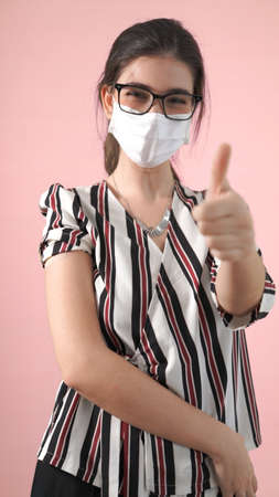Young woman showing COVID-19 vaccine bandage merrily in concept of coronavirus vaccination program to vaccinate citizen .の写真素材