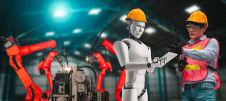 Mechanized industry robot and human worker working together in future factory . Concept of artificial intelligence for industrial revolution and automation manufacturing process .の写真素材